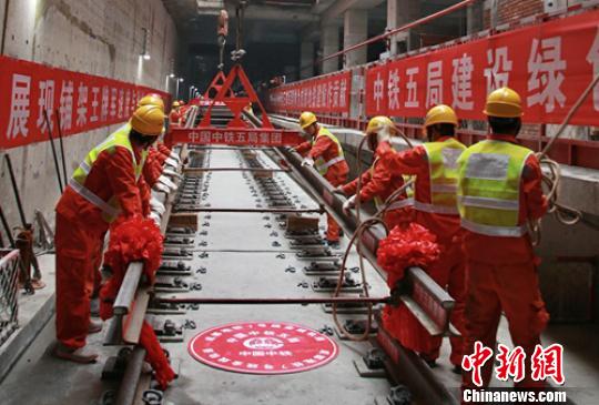工人师傅正在铺成都地铁首条环线7号线最后一段轨排。　刘忠俊 摄